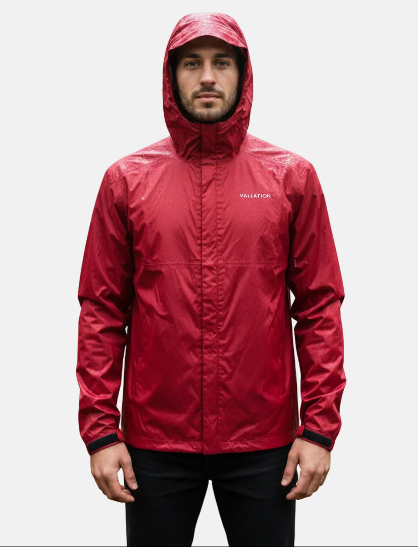 A man wearing a red hooded rain jacket with a Vallation logo